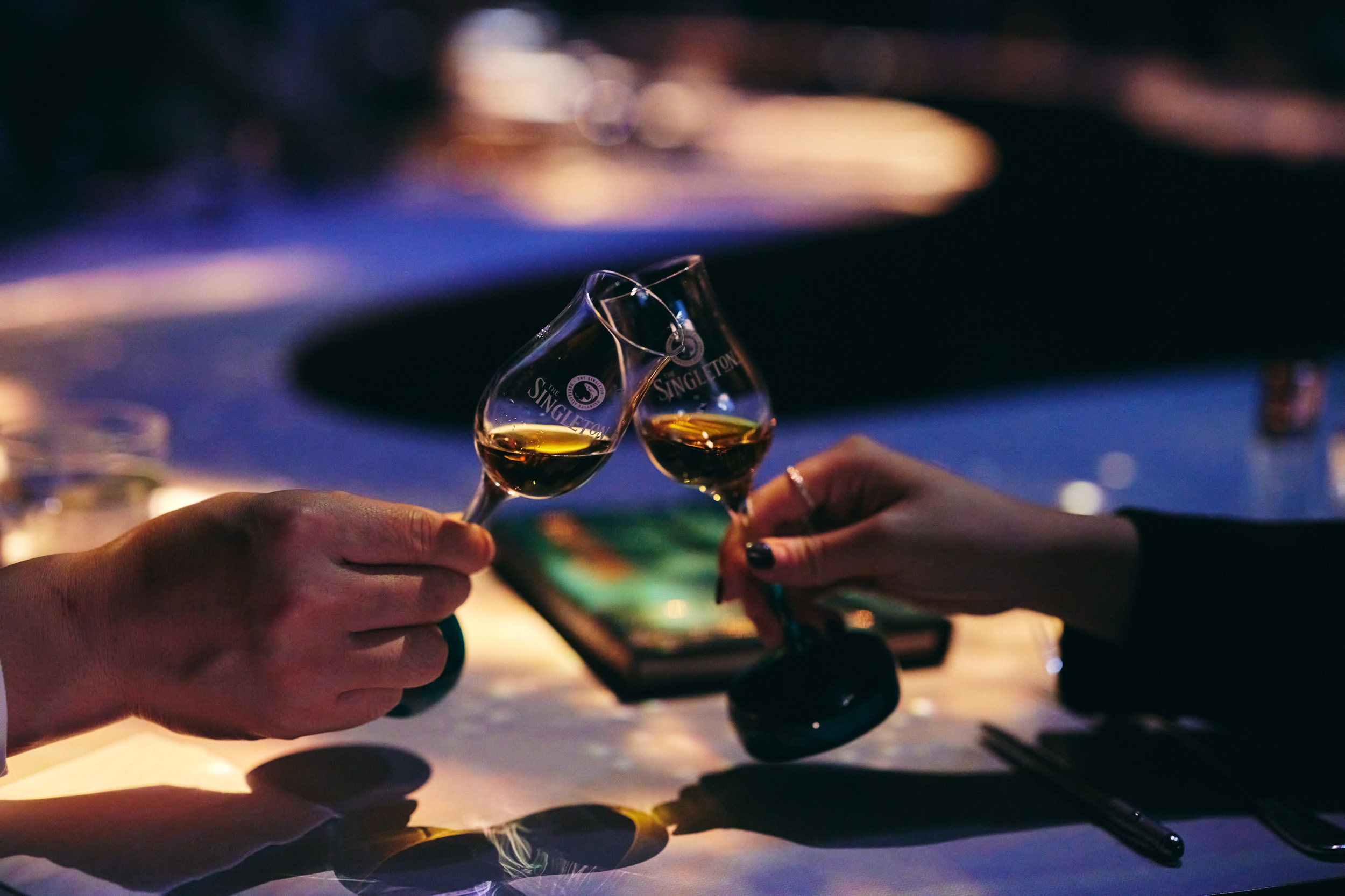 Гости чокаются бокалами с виски The Singleton во время камерного мероприятия