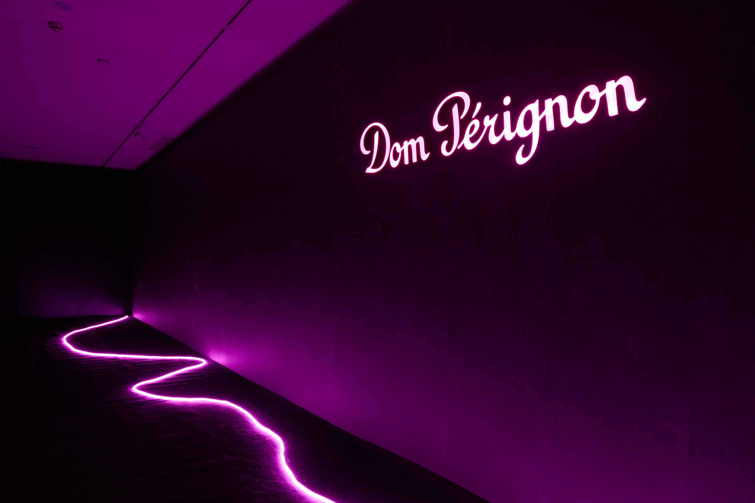 Едва освещенный коридор с ярким логотипом Dom Perignon